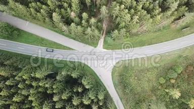 从空中俯瞰森林中央的一条道路，汽车<strong>驶过</strong>，还有照相机